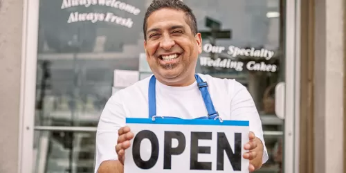 Man outside business with an open sign